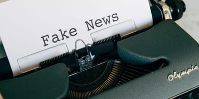 Eine alte Schreibmaschine, die einen Zettel mit dem Titel "Fake News" enthält