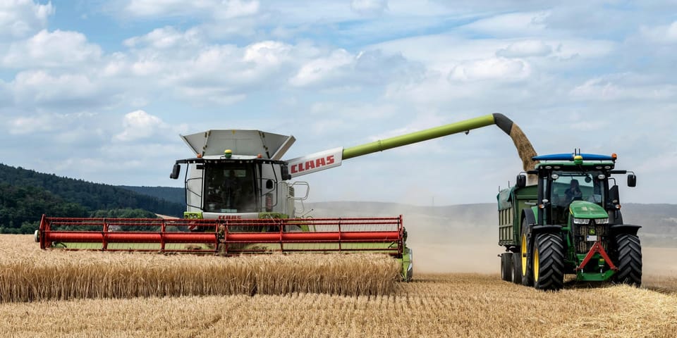 Ein Mähdrescher, der die Ernte in einen Traktor umfüllt